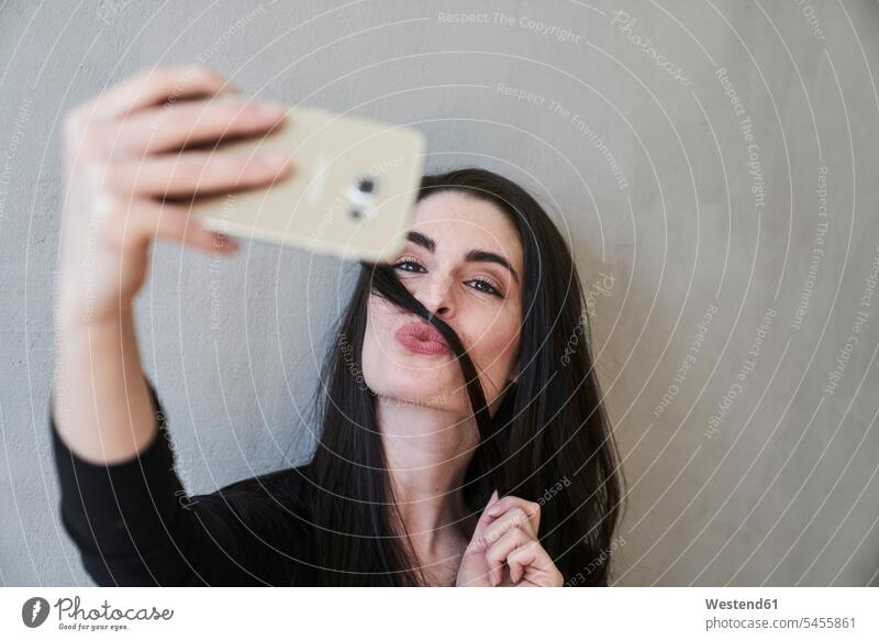 Junge Frau schmollt und macht ein Selfie Selfies Handy Mobiltelefon Handies Handys Mobiltelefone weiblich Frauen Telefon telefonieren Kommunikation
