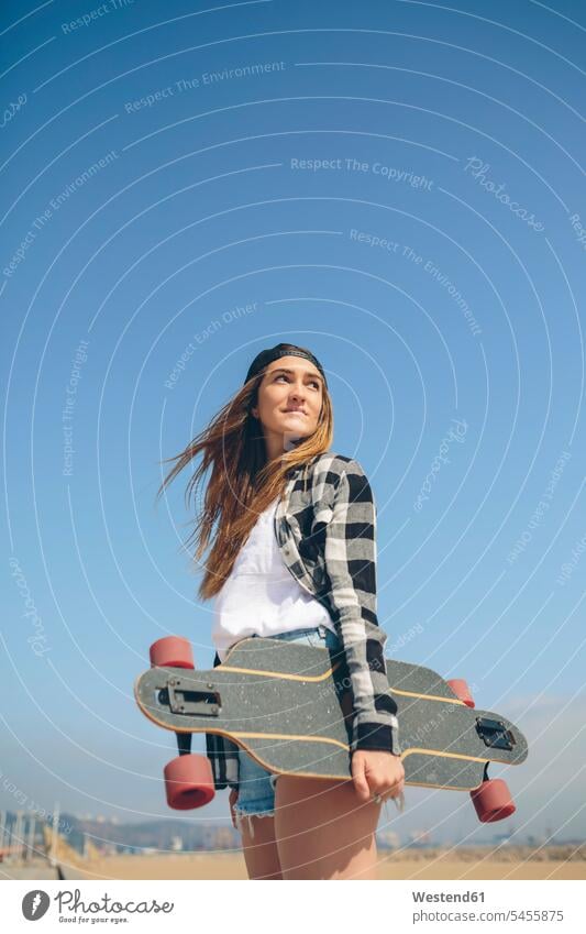 Porträt einer jungen Frau mit Longboard Skateboarderin Skateboardfahrerin Skaterin Skateboarderinnen Skaterinnen Skateboardfahrerinnen Skateboarders Mensch