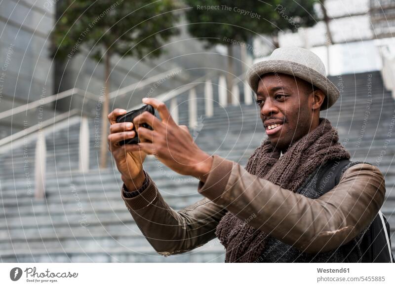 Lächelnder Mann macht Selfie mit Smartphone Selfies Männer männlich iPhone Smartphones Erwachsener erwachsen Mensch Menschen Leute People Personen Handy