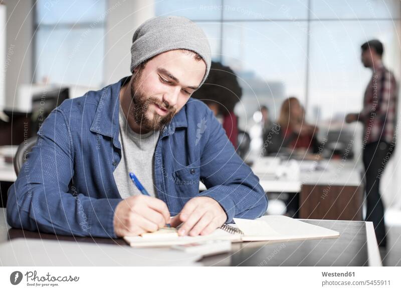 Mann schreibt Notizen am Schreibtisch im Büro Männer männlich aufschreiben notieren Office Büros Erwachsener erwachsen Mensch Menschen Leute People Personen