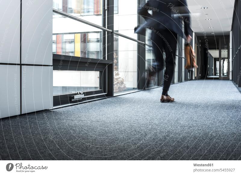 Geschäftsmann läuft im Korridor eines Bürogebäudes Flur Gang Fure Korridore Gänge Gaenge schnell Schnelligkeit geschwind laufen rennen Eile eilig Bürohaus