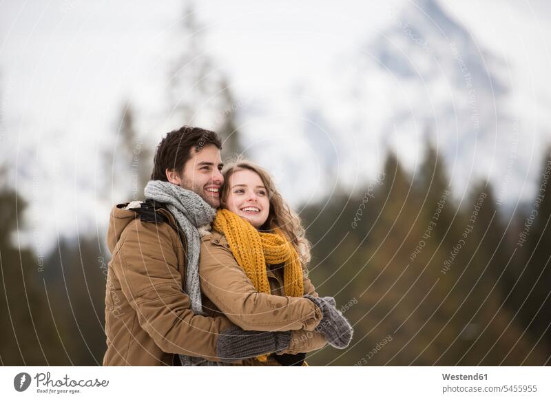 Porträt eines glücklichen jungen Paares in Winterlandschaft Pärchen Partnerschaft winterlich Winterzeit Mensch Menschen Leute People Personen Natur Glück