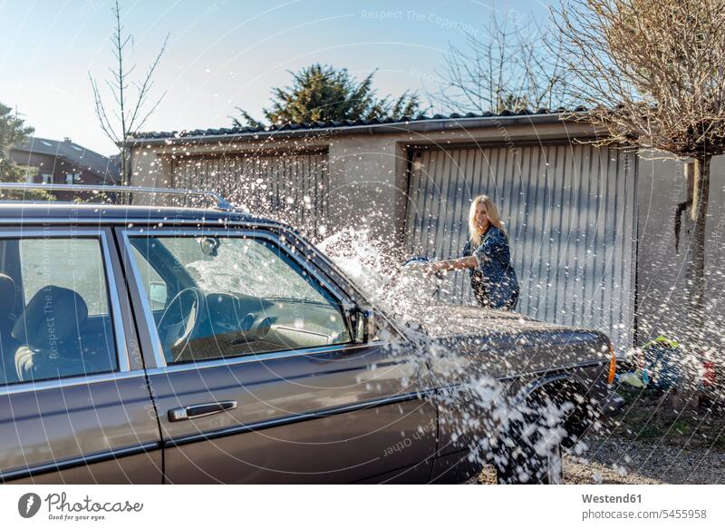 Frau, die ihr Auto wäscht Wagen PKWs Automobil Autos waschen weiblich Frauen Kraftfahrzeug Verkehrsmittel KFZ Erwachsener erwachsen Mensch Menschen Leute People