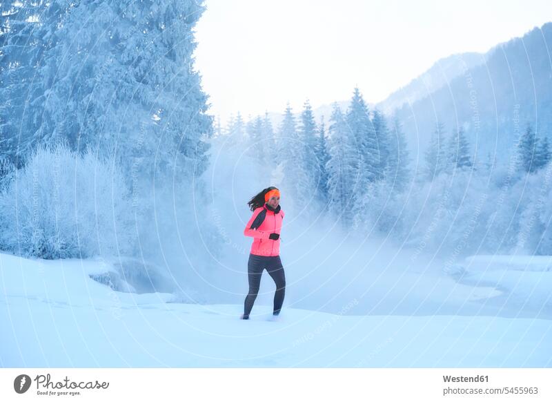 Deutschland, Bayern, Isartal, Vorderriss, Frau joggt im Winter trainieren laufen rennen Joggen Jogging weiblich Frauen Fitness fit Gesundheit gesund Sport