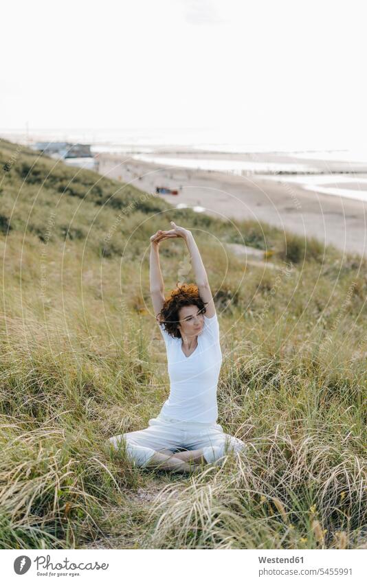 Frau streckt sich in Stranddüne Sanddüne Sanddünen Yoga Yoga-Übungen Yogauebungen Yogaübungen Jogauebung Jogauebungen weiblich Frauen Beach Straende Strände