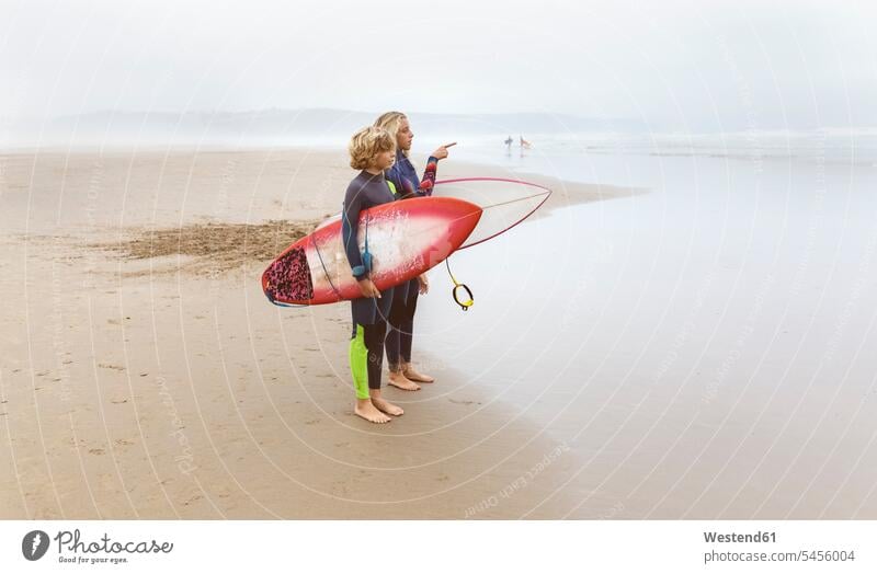 Spanien, Aviles, zwei junge Surfer am Strand Beach Straende Strände Beaches Wellenreiter Teenager Jugendliche Heranwachsende Pubertierende stehen stehend steht