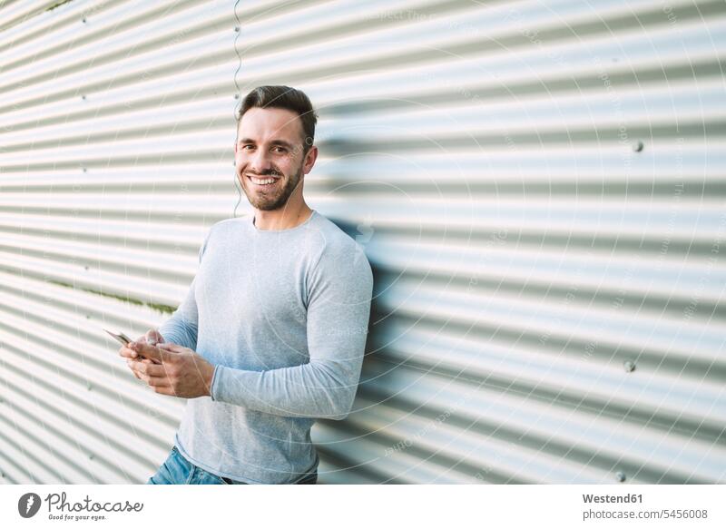 Porträt eines lachenden Mannes mit Smartphone Portrait Porträts Portraits Männer männlich iPhone Smartphones positiv Emotion Gefühl Empfindung Emotionen Gefühle