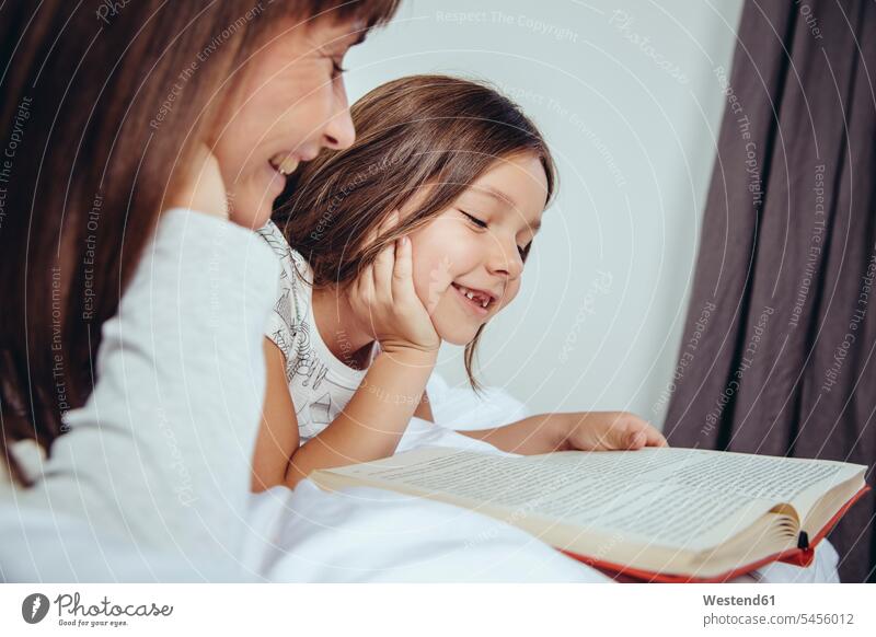 Mutter und Tochter lesen Buch im Bett entspannt liegen Eltern Familie Mensch Kind Entspannung Lebensqualität Zuhause Gemeinsam Fürsorge Quality Time Hobby