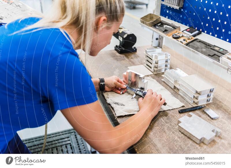 Frau misst Metallwerkstück Fabrik Fabriken arbeiten Arbeit messen abmessen weiblich Frauen Erwachsener erwachsen Mensch Menschen Leute People Personen Industrie