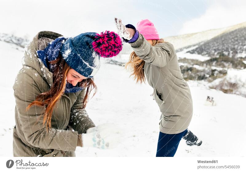 Freunde bei einer Schneeballschlacht im Schnee Freundschaft Kameradschaft lachen Winter winterlich Winterzeit Schneeballschlachten Freundinnen spielen Wetter