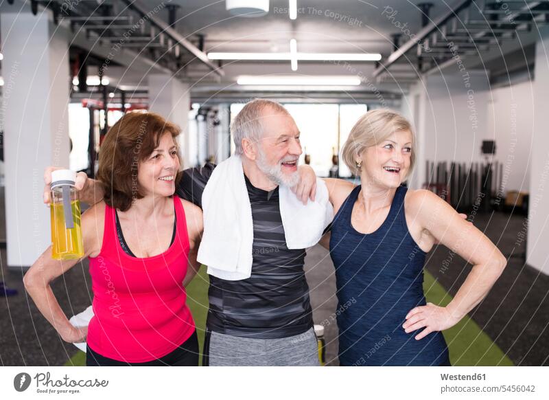 Gruppe fitter Senioren im Fitnessstudio macht eine Pause Fitnessclubs Fitnessstudios Turnhalle Freunde trainieren alte ältere lächeln Gesundheit gesund Sport