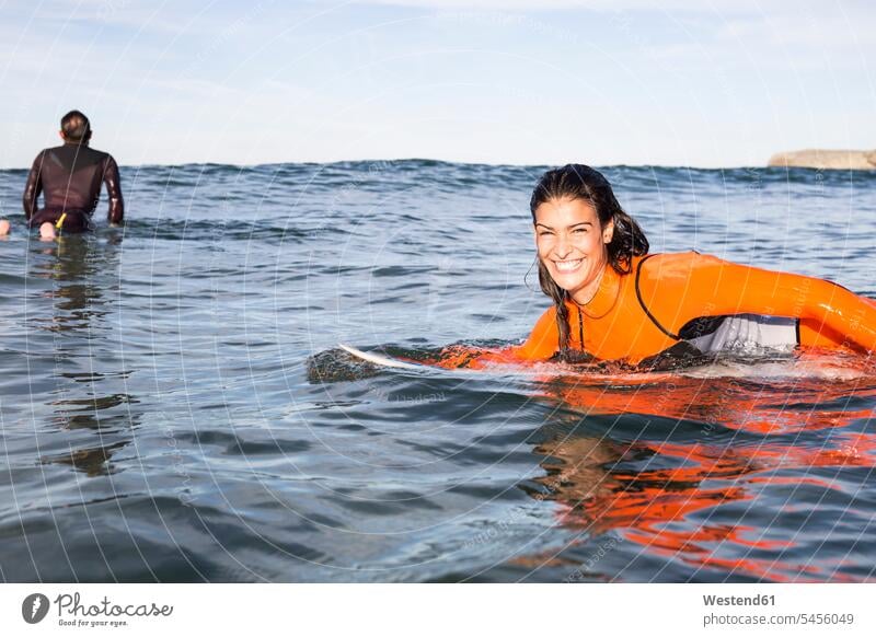 Zwei Surfer im Wasser Surfbrett Surfbretter surfboard surfboards lächeln Meer Meere Wellenreiter Surfen Surfing Wellenreiten Wassersport Sport Gewässer