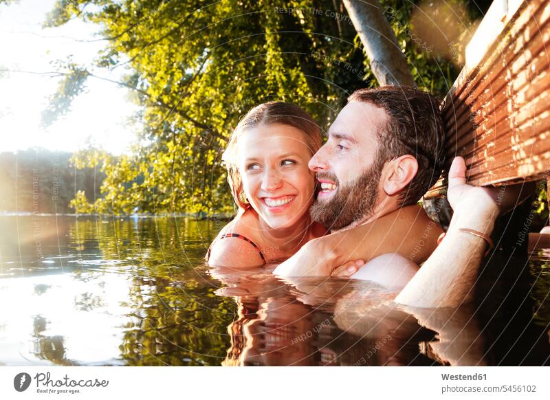 Glückliches junges Paar in einem See Seen Pärchen Paare Partnerschaft schwimmen glücklich glücklich sein glücklichsein Gewässer Wasser Mensch Menschen Leute