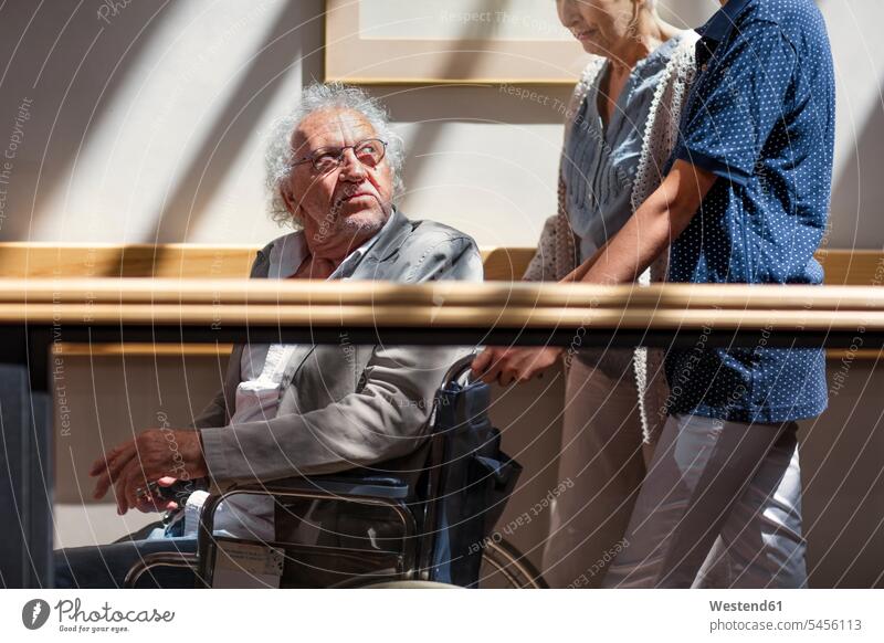 Geriatrische Krankenschwester, die älteren Männern und Frauen hilft, den Korridor hinunterzugehen Seniorin Seniorinnen alt helfen mithelfen Hilfsbereitschaft