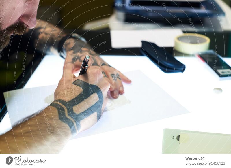 Tätowierer entwirft Motiv auf Leuchttisch im Studio entwerfen Entwurf Tattoo Tätowierungen Tatoos Taetowierung Tattoos Taetowierungen Mann Männer männlich