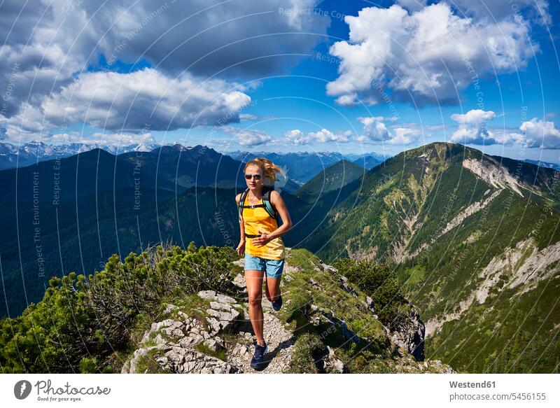 Deutschland, Bayern, Junge Frau läuft in den Bergen weiblich Frauen Gebirge Berglandschaft Gebirgslandschaft Gebirgskette Gebirgszug Natur Joggerin Joggerinnen
