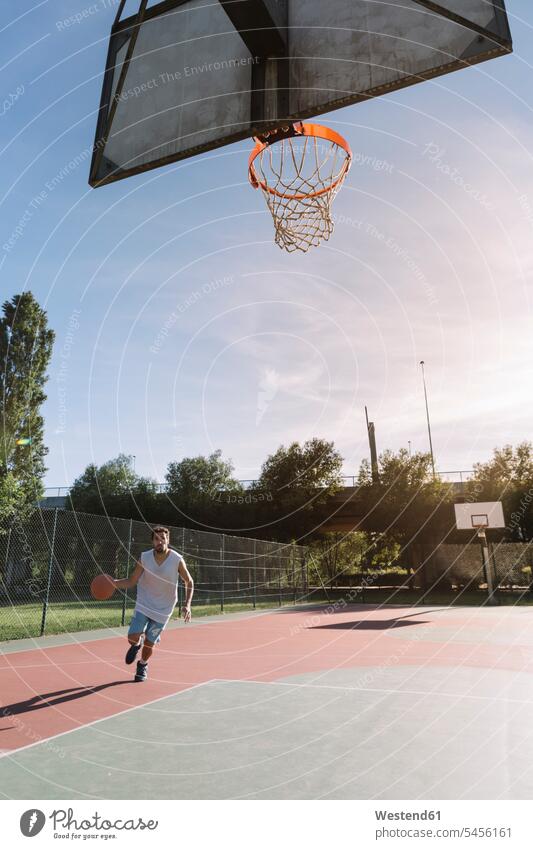 Mann spielt Basketball Basketbaelle Basketbälle springen hüpfen Freizeit Muße Sport Männer männlich Basketballspieler Basketballer werfen Wurf Sprung Spruenge