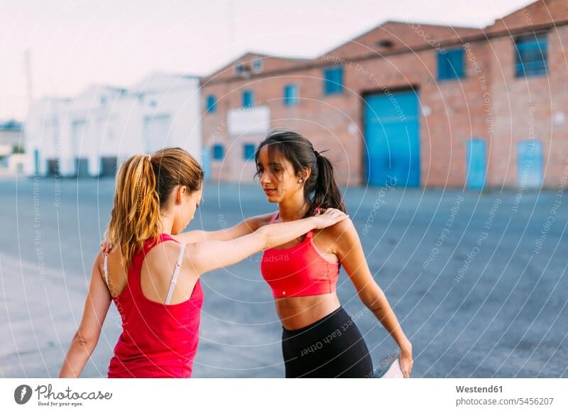 Zwei aktive Frauen, die sich gegenseitig dehnen und stützen Trainieren Übung Üben Übungen weiblich Freundinnen strecken Erwachsener erwachsen Mensch Menschen