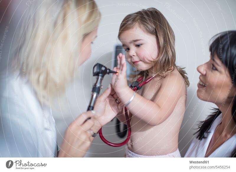Kleines Mädchen in der Pädiatrie beim Spielen mit dem Otoskop Abhören abhorchen Auskultation abhoeren Stethoskop Stethoskope Kinderarzt Kinderärzte Kinderaerzte