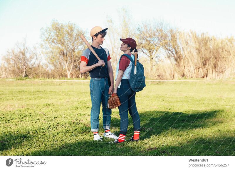 Junges Paar mit Baseballausrüstung im Park Baseballspiel Baseballspieler Baseballer Pärchen Paare Partnerschaft Sport Mensch Menschen Leute People Personen