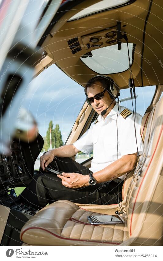Porträt eines Piloten im Cockpit eines Hubschraubers Helikopter Verkehrswesen Transportwesen Portrait Porträts Portraits Mann Männer männlich Tablet