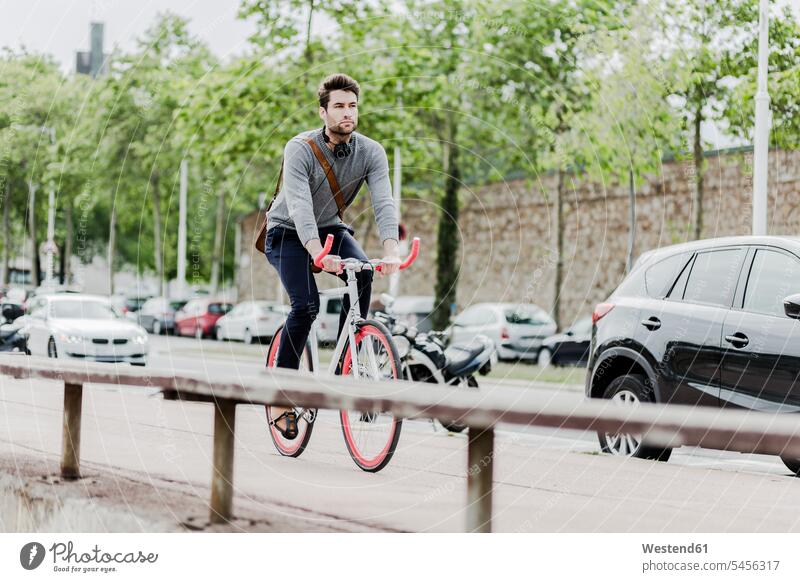 Junger Mann fährt Rennrad radfahren fahrradfahren radeln Fahrrad Bikes Fahrräder Räder Rad Männer männlich Raeder Erwachsener erwachsen Mensch Menschen Leute