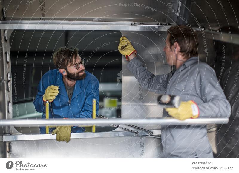 Zwei Männer diskutieren im Inneren eines Stahlbehälters in der Fabrik arbeiten Arbeit Kollegen Arbeitskollegen Mann männlich Erwachsener erwachsen Mensch
