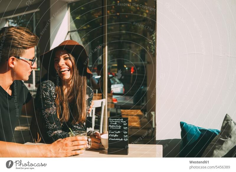 Paar sitzt in einem Café und amüsiert sich Pärchen Paare Partnerschaft Cafe Kaffeehaus Bistro Cafes Cafés Kaffeehäuser Mensch Menschen Leute People Personen