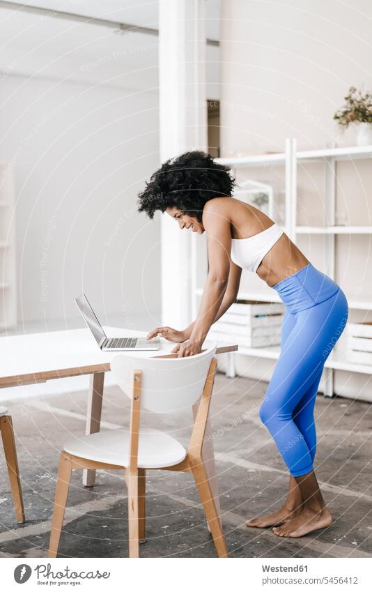 Fitte junge Frau mit Laptop zu Hause Training trainieren fit lernen arbeiten Arbeit Online Notebook Laptops Notebooks weiblich Frauen Internet Technologie