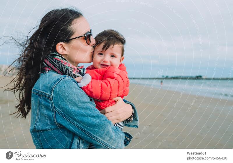Porträt eines lächelnden Mädchens auf den Armen seiner Mutter am Strand Mami Mutti Mütter Mama Baby Babies Babys Säuglinge Kind Kinder Beach Straende Strände