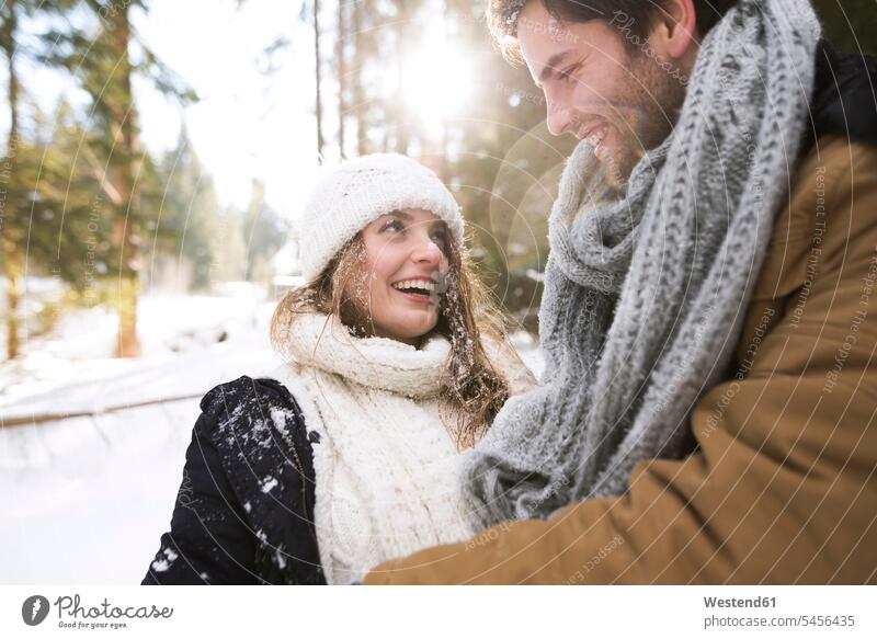 Glückliches junges Paar im Winter von Angesicht zu Angesicht Pärchen Paare Partnerschaft Mensch Menschen Leute People Personen glücklich glücklich sein