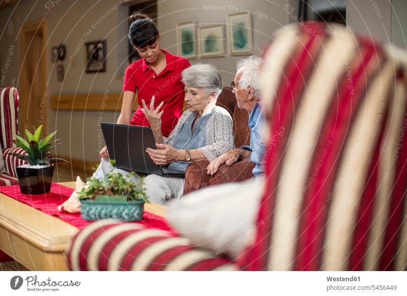 Senioren im Altersheim beim Betrachten von Fotoalben Laptop Notebook Laptops Notebooks Altenpflege Altenheim Seniorenheim Neugier Neugierde neugierig