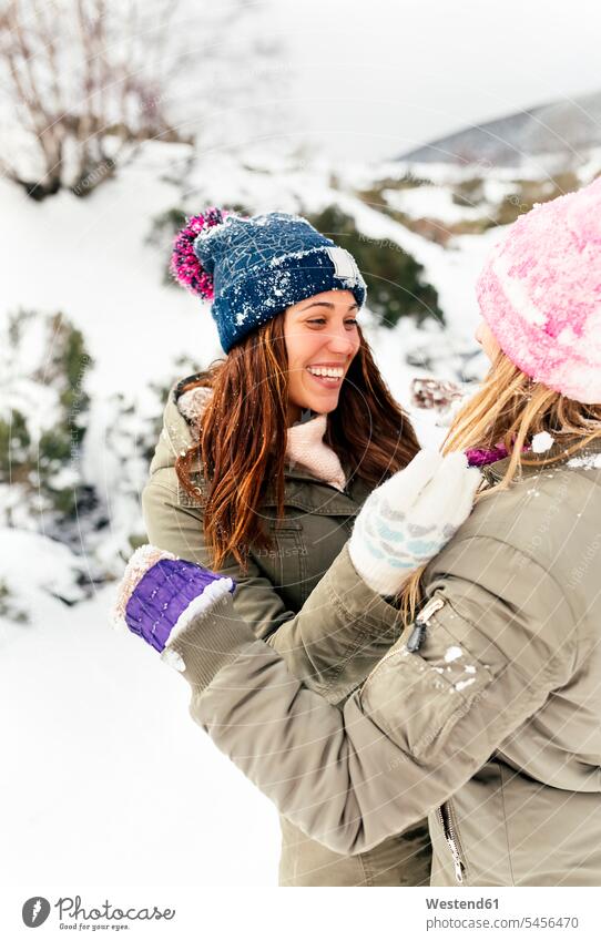 Zwei Freunde amüsieren sich im Schnee Freundschaft Kameradschaft spielen Freundinnen Winter winterlich Winterzeit lachen Wetter positiv Emotion Gefühl