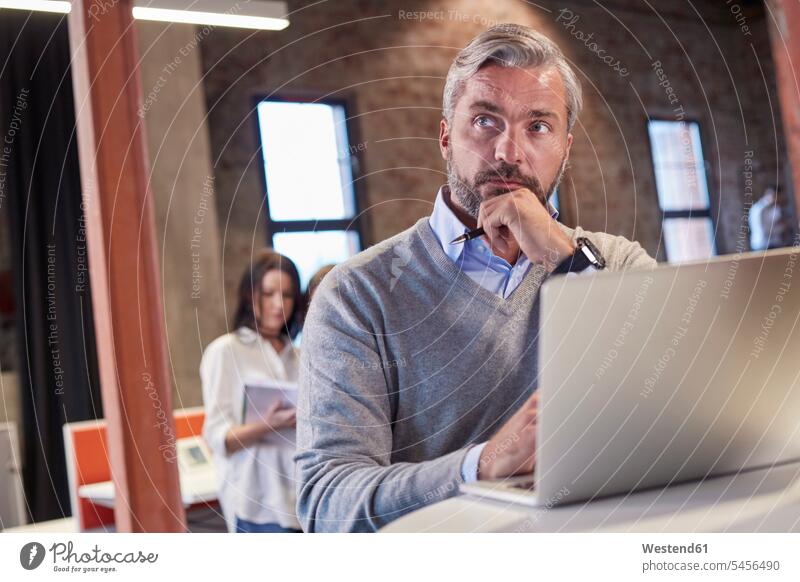 Reifer Mann sitzt am Laptop und denkt nach Notebook Laptops Notebooks sitzen sitzend nachdenken überlegen arbeiten Arbeit Büro Office Büros Laptop benutzen