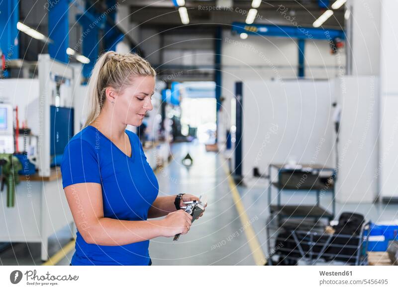 Frau misst Metallwerkstück in einer Industriefabrik Fabrik Fabriken arbeiten Arbeit weiblich Frauen messen abmessen Erwachsener erwachsen Mensch Menschen Leute