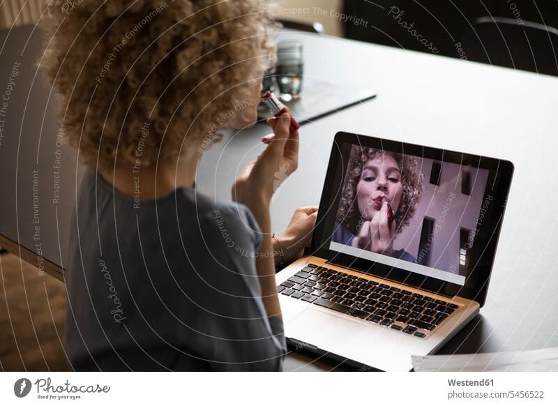 Frau im Büro schminkt sich mit einem Laptop-Monitor als Spiegel Konferenzraum Konferenzraeume Konferenzräume Lippenstift Lippenstifte Office Büros weiblich