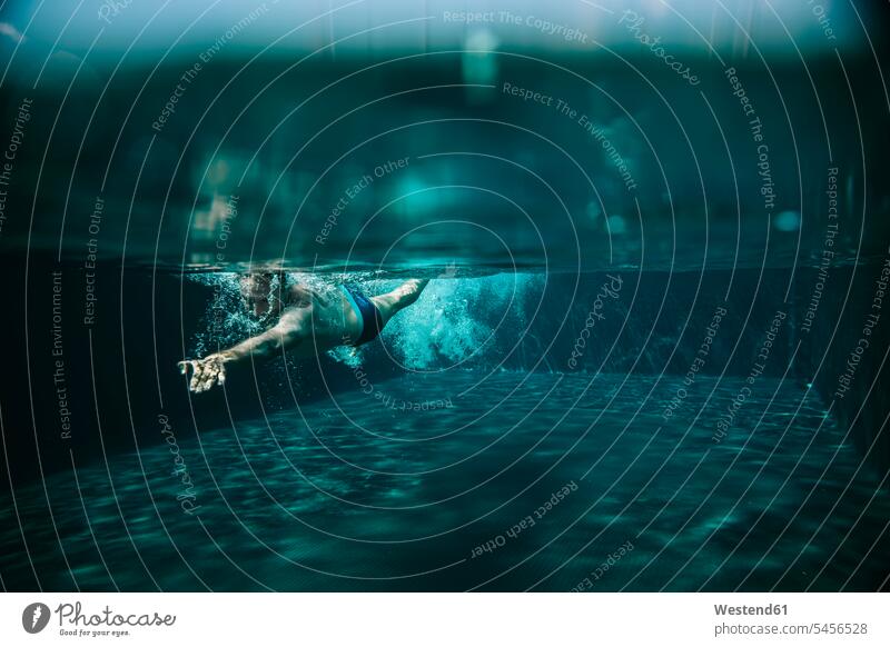 In einem Schwimmbad schwimmender Mann Männer männlich Wasser Unterwasser unter Wasser Unterwasseraufnahme Unterwasserfoto Swimmingpool Swimmingpools