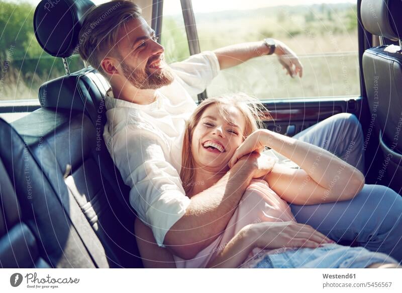 Glückliches junges Paar entspannt im Auto Spaß Spass Späße spassig Spässe spaßig Wagen PKWs Automobil Autos lachen Pärchen Paare Partnerschaft glücklich