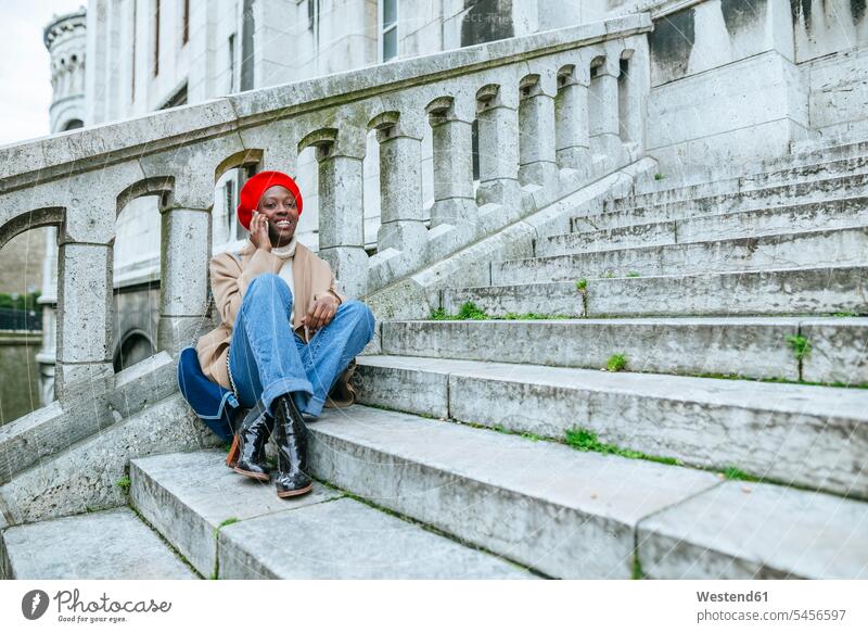 Junge Frau in Paris sitzt auf der Treppe und telefoniert weiblich Frauen Sacre Coeur Treppenaufgang alleinreisend allein reisend Alleinreisende Alleinreisender