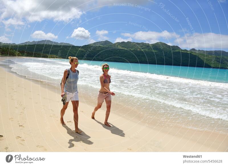 Dominikanische Republik, Samana, zwei Frauen gehen am Strand spazieren Beach Straende Strände Beaches gehend geht Freundinnen weiblich Freunde Freundschaft