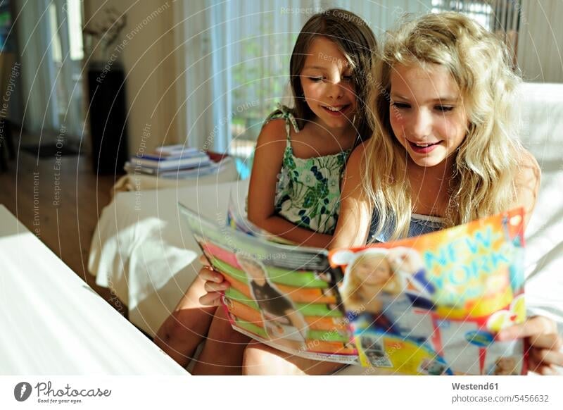 Zwei Mädchen lesen Jugendzeitschrift Lektüre weiblich Magazin Magazine Freundinnen lächeln Kind Kinder Kids Mensch Menschen Leute People Personen Zeitschrift
