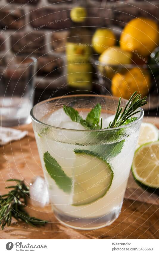 Glas Gin Tonic mit Limette, Minze, Rosmarin und Eis Trinkgläser Gläser Trinkglas Tonic Water Genuss genießen Genuß geniessen Lifestyle Lebensstil hölzern Aroma