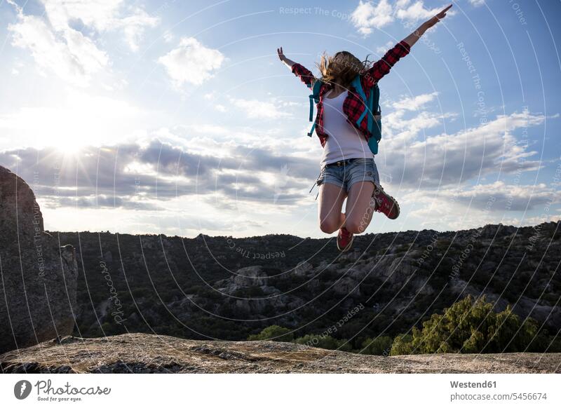 Spanien, Madrid, junge Frau springt während eines Trekking-Tages springen hüpfen weiblich Frauen Berg Berge Freude freuen wandern Wanderung Fels Felsen Sprung