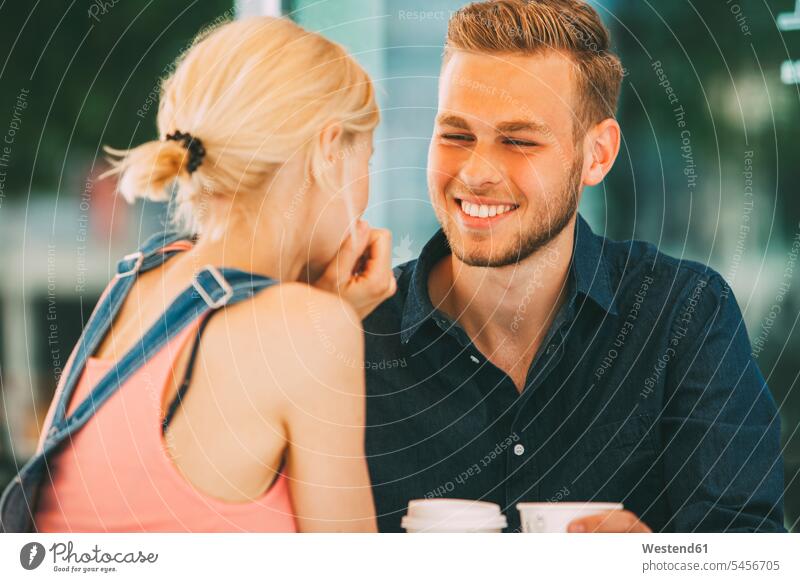 Porträt eines glücklichen jungen Mannes, der mit seiner Freundin Kaffee trinkt Paar Pärchen Paare Partnerschaft Mensch Menschen Leute People Personen Glück