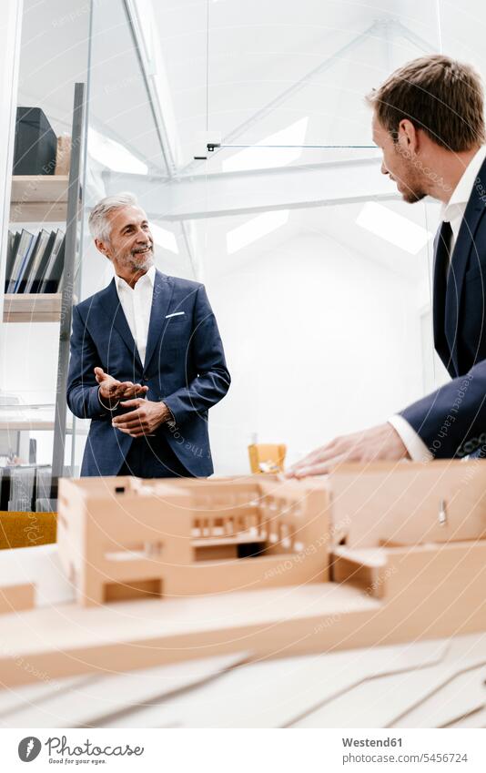 Zwei Geschäftsleute mit Architekturmodell im Amt Modell Modelle Architekten Kollegen Arbeitskollegen lächeln Büro Office Büros Geschäftsmann Businessmann