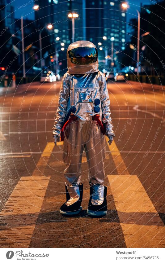 Spaceman stehend auf einer Straße in der Stadt bei Nacht staedtisch städtisch nachts steht Astronaut Astronauten Raumfahrer Weltraumfahrer Strassen Straßen