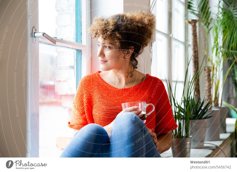 Frau mit einem Kaffee, die im Büro aus dem Fenster schaut Job Berufe Berufstätigkeit Beschäftigung Jobs geschäftlich Geschäftsleben Geschäftswelt