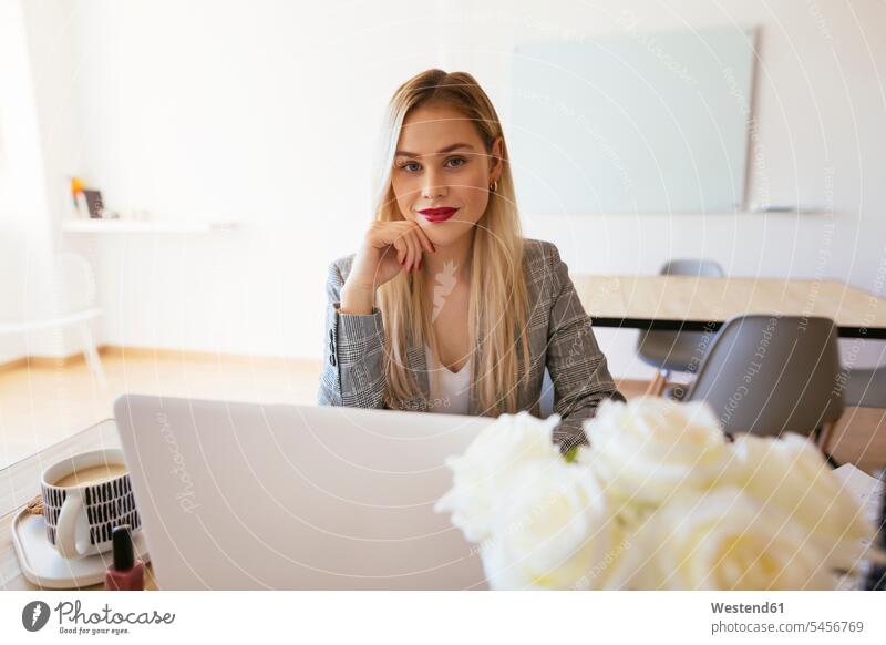 Junge Geschäftsfrau, die im Büro arbeitet und einen Laptop benutzt blond blonde Haare blondes Haar Geschäftsfrauen Businesswomen Businessfrauen Businesswoman