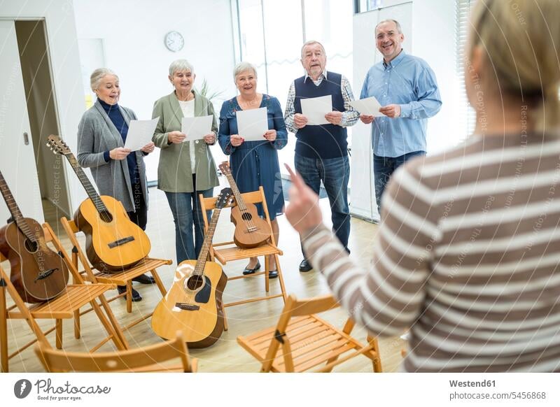 Senioren im Altersheim musizieren und singen im Chor Chöre Sängerchor Sängerchöre Instrument Instrumente Musikinstrumente Gitarren Stuehle Stühle ausüben