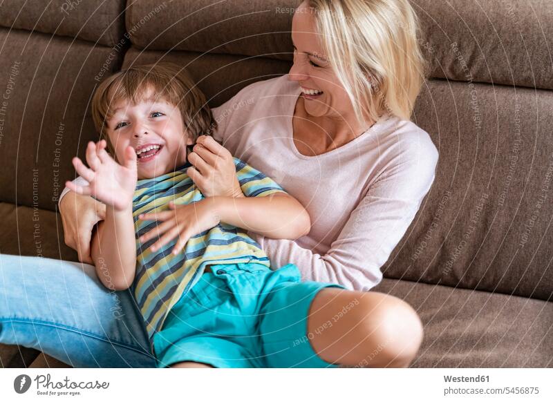 Verspielte Mutter und Sohn zu Hause auf der Couch Couches Liege Sofas begeistert Enthusiasmus enthusiastisch Überschwang Überschwenglichkeit entspannen relaxen